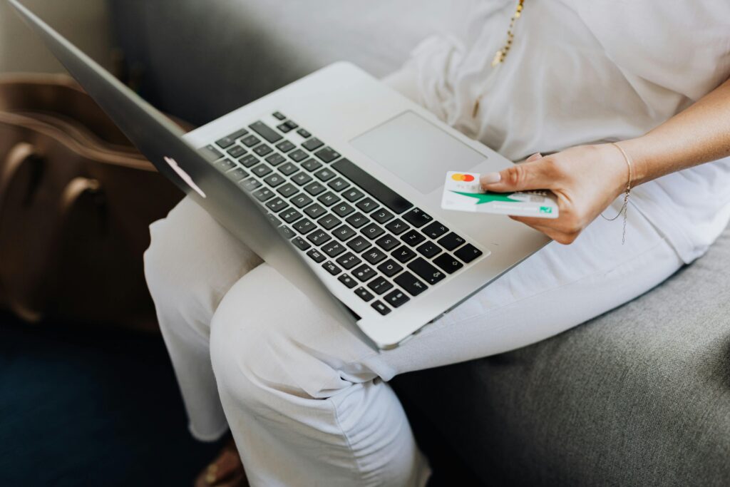 pexels-karolina-grabowska-4968386 Laptop on top of a woman's lap while holding a credit card - Photo By: Kaboompics.com